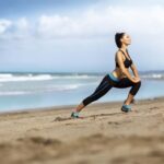 Attractive woman stretching on the beach